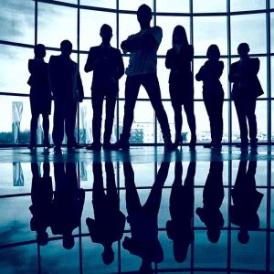 Business team standing against window with leader in front